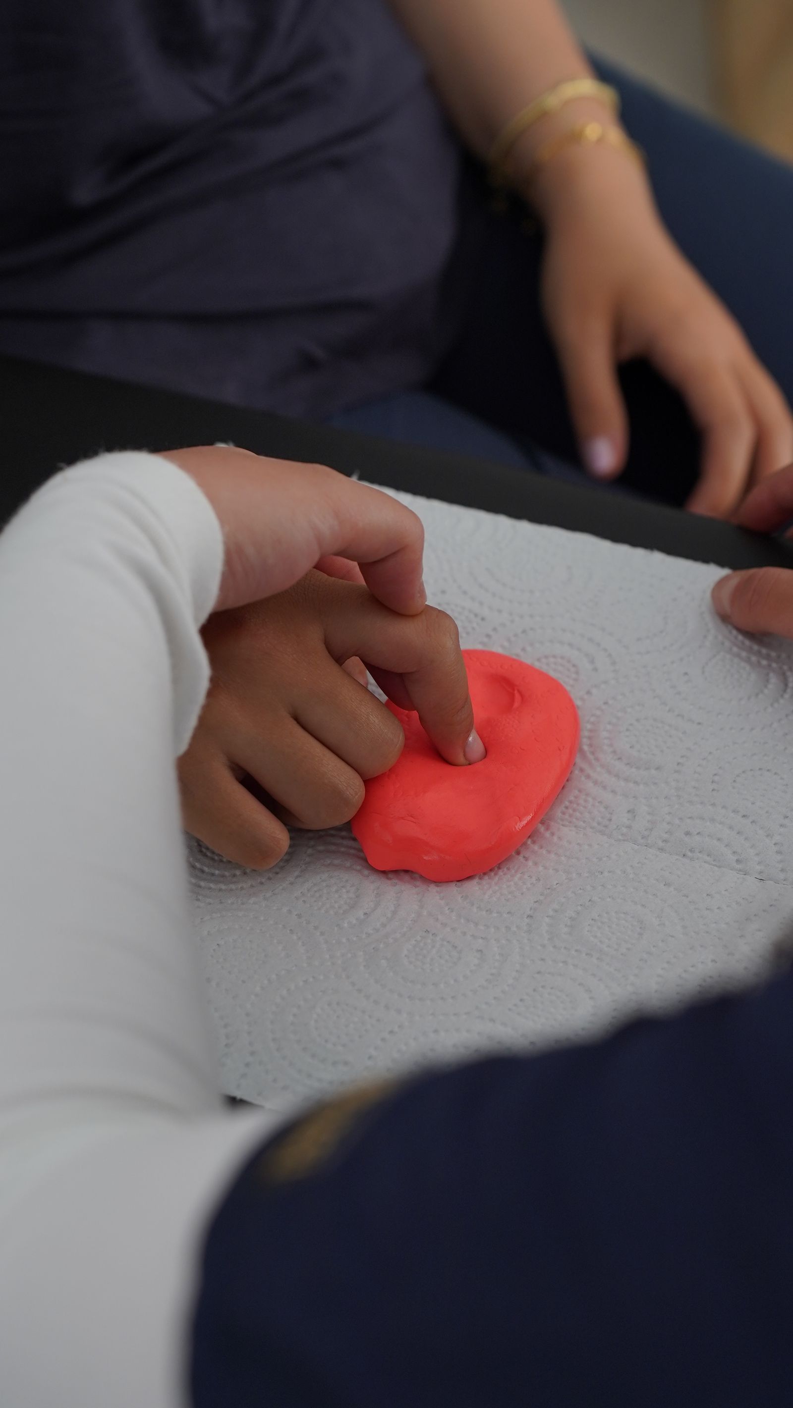 Occupational therapist guiding a patient through hand therapy with therapy putty